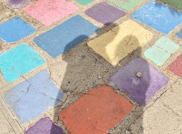 shadow of couple cast onto colorful stone paving