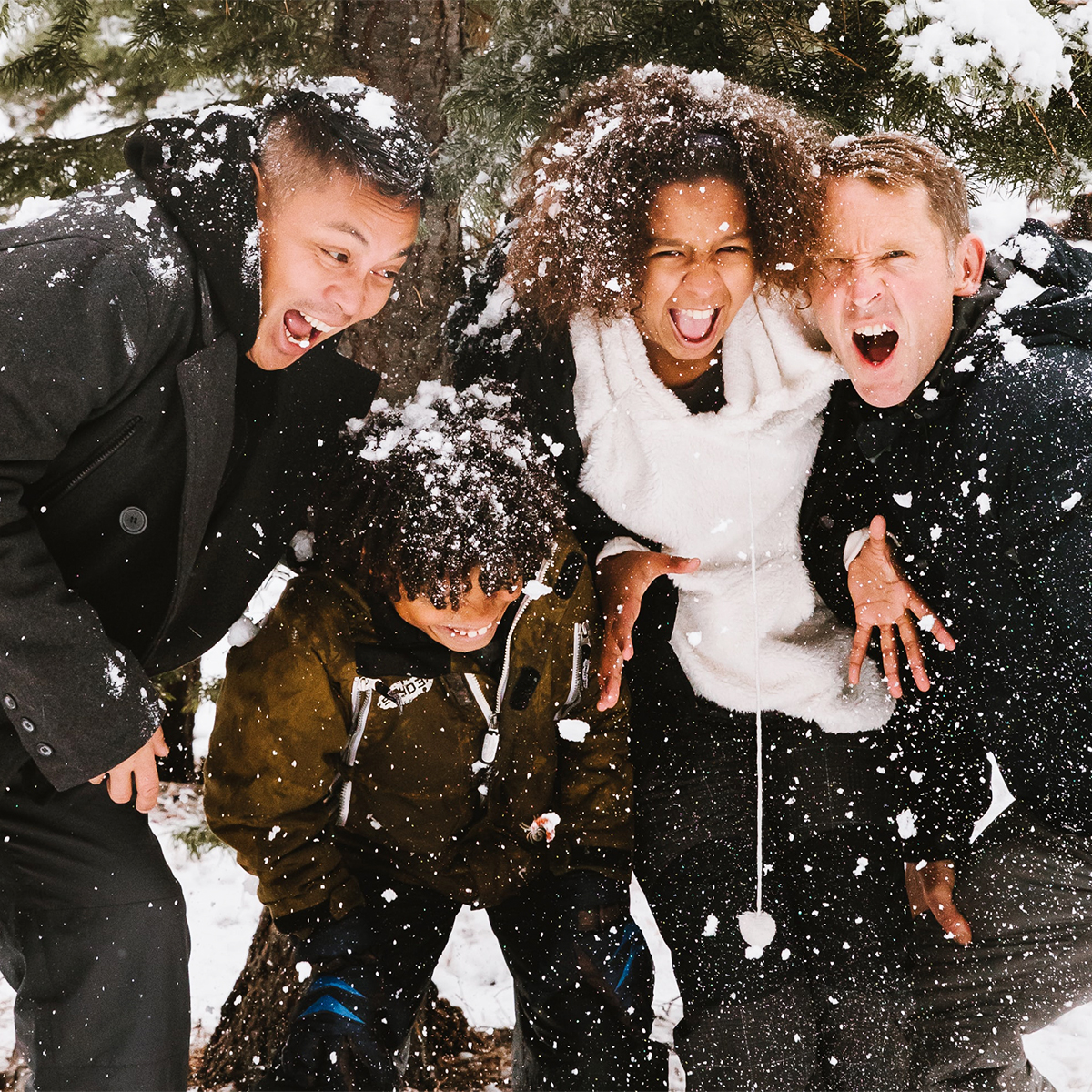 Four adolescent boys laughing in the snow