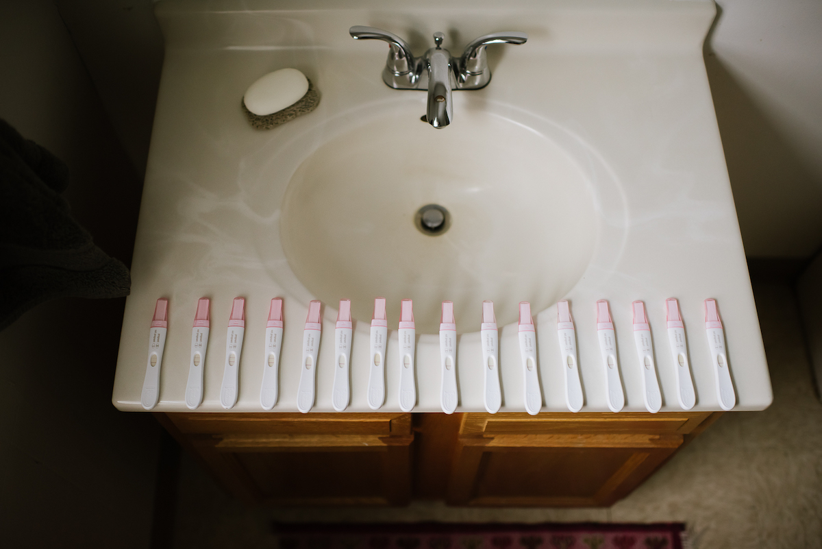Photo by Martha Swann-Quinn of several pregnancy tests lined up on the edge of the sink