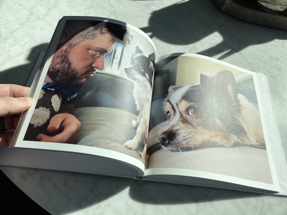 Artifact Uprising Photo-Wrapped Hardcover Book opened to full-page image of small dog and its owner face to face