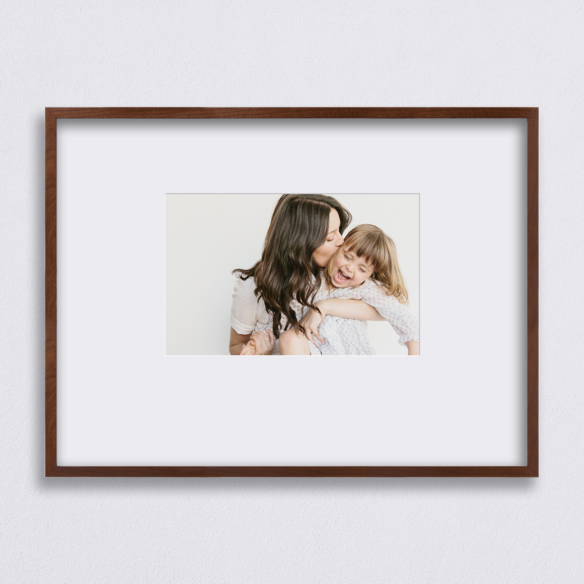 40 x 30 inch Artifact Uprising Deep Set Frame in Black finish matted to 22 x 14 inch featuring photo of mother kissing daughter on the cheek as she laughs