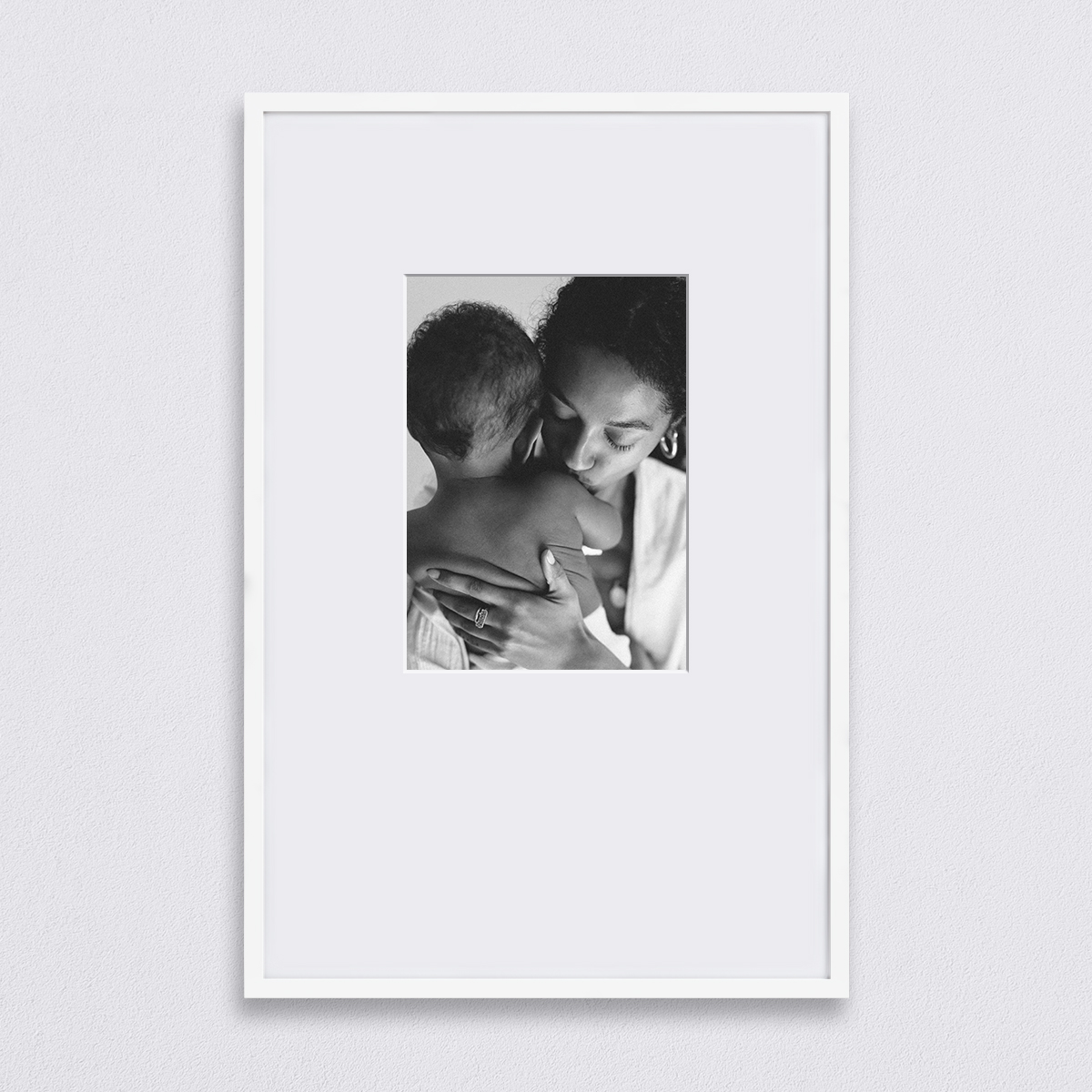 Black and white photo of mother holding newborn matted to 10 x 14 inch inside of a white 20 x 30 inch Artifact Uprising Gallery Frame