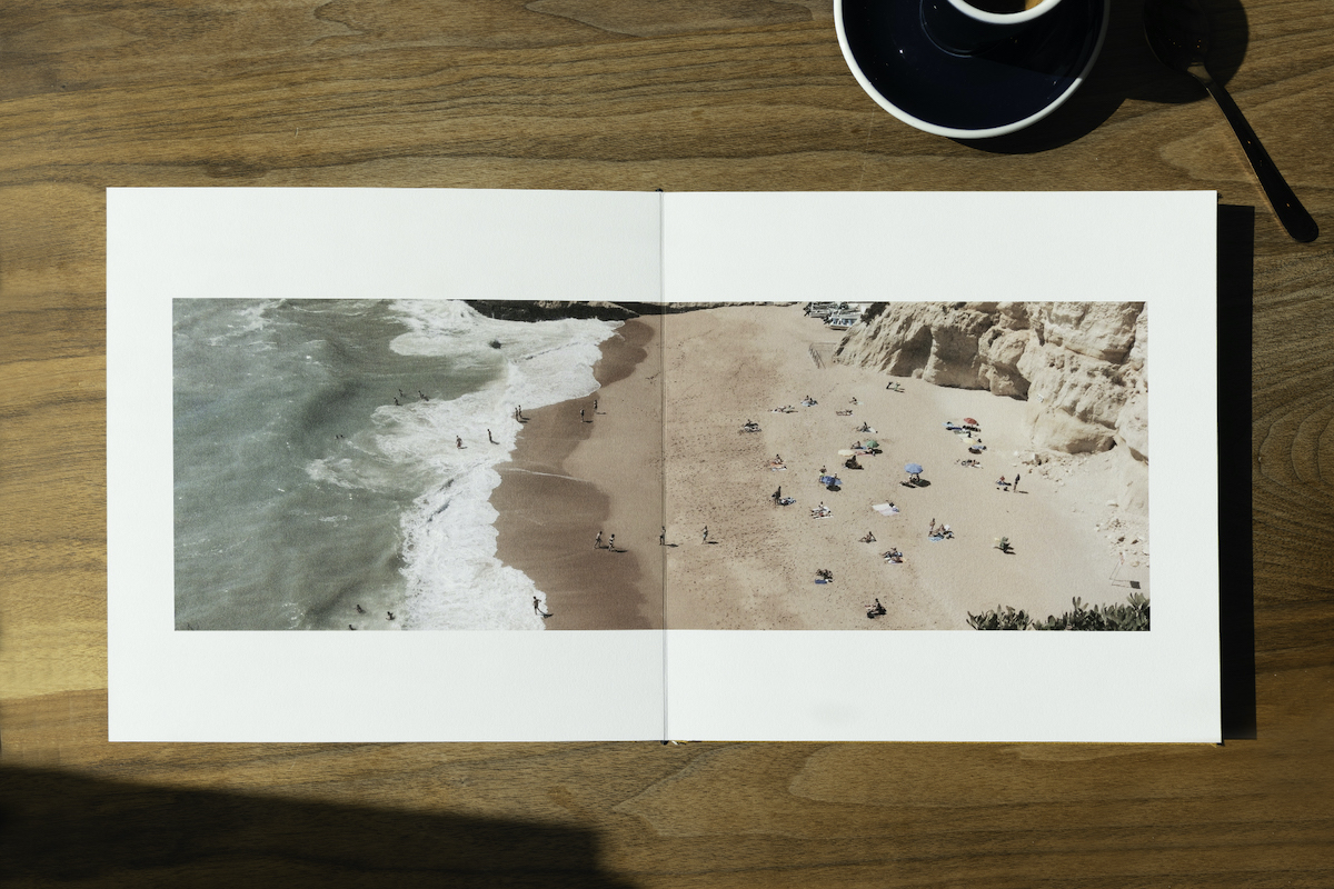 Artifact Uprising Layflat Photo Album opened to two-page image of a beach taken from overhead