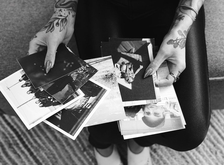 zoomed in black and white photo of hands holding photo prints of different sizes