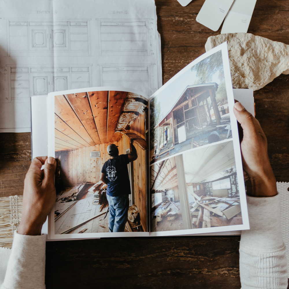 Hands flipping through Artifact Uprising Hardcover Photo Book featuring photos of home renovation