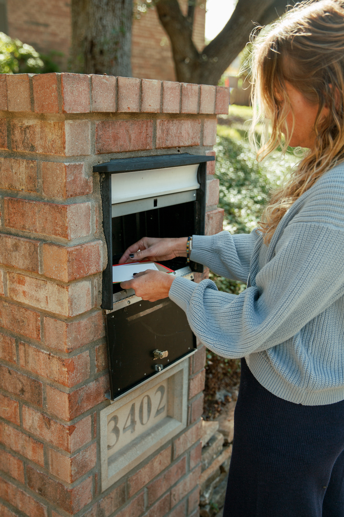 checking a large mailbox and pulling out envelopes